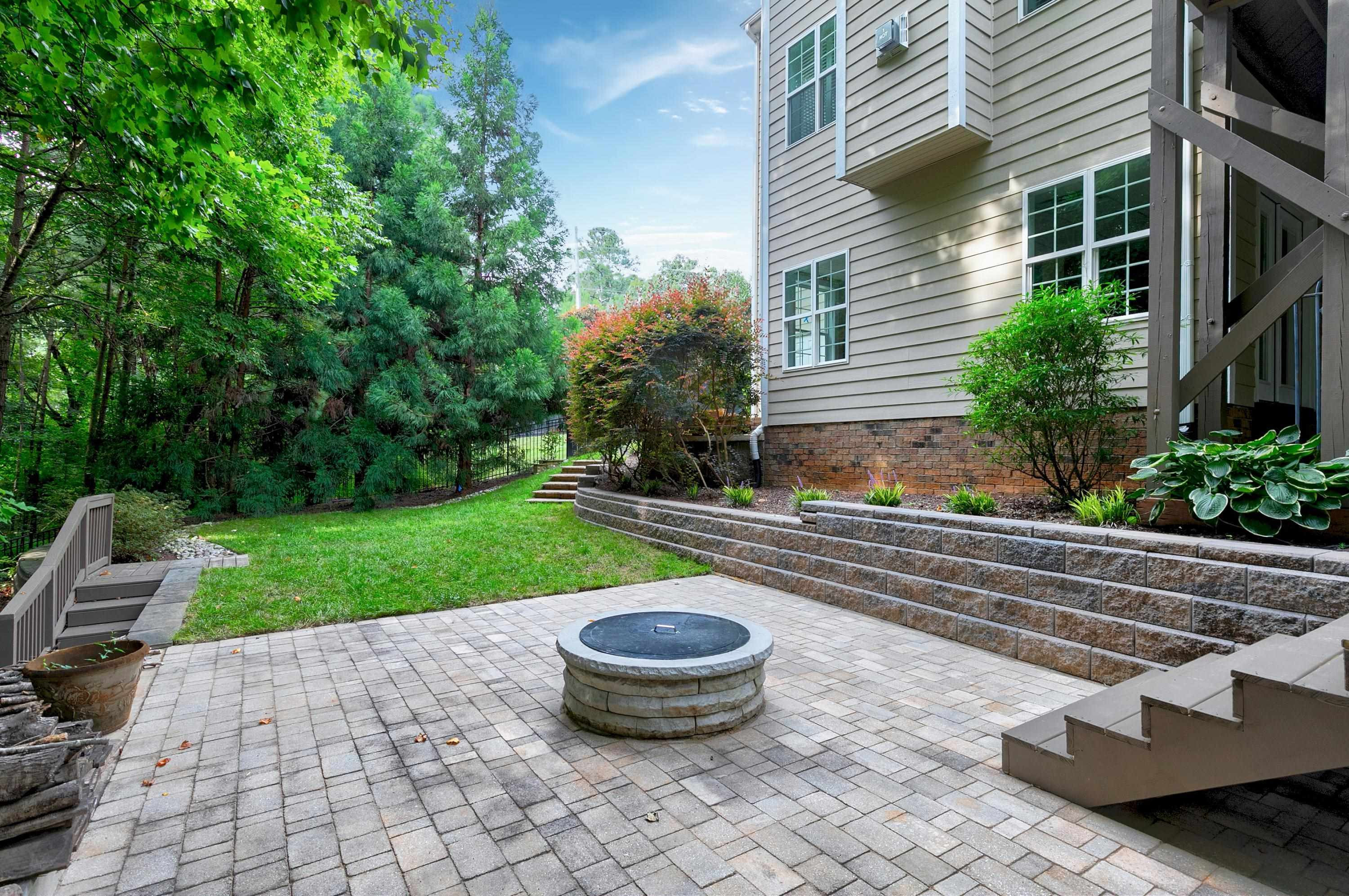 8431 Henderson Road Apex, NC 27539 - Photo 50 of 56 a view of a backyard with table and chairs potted plants and water fountain