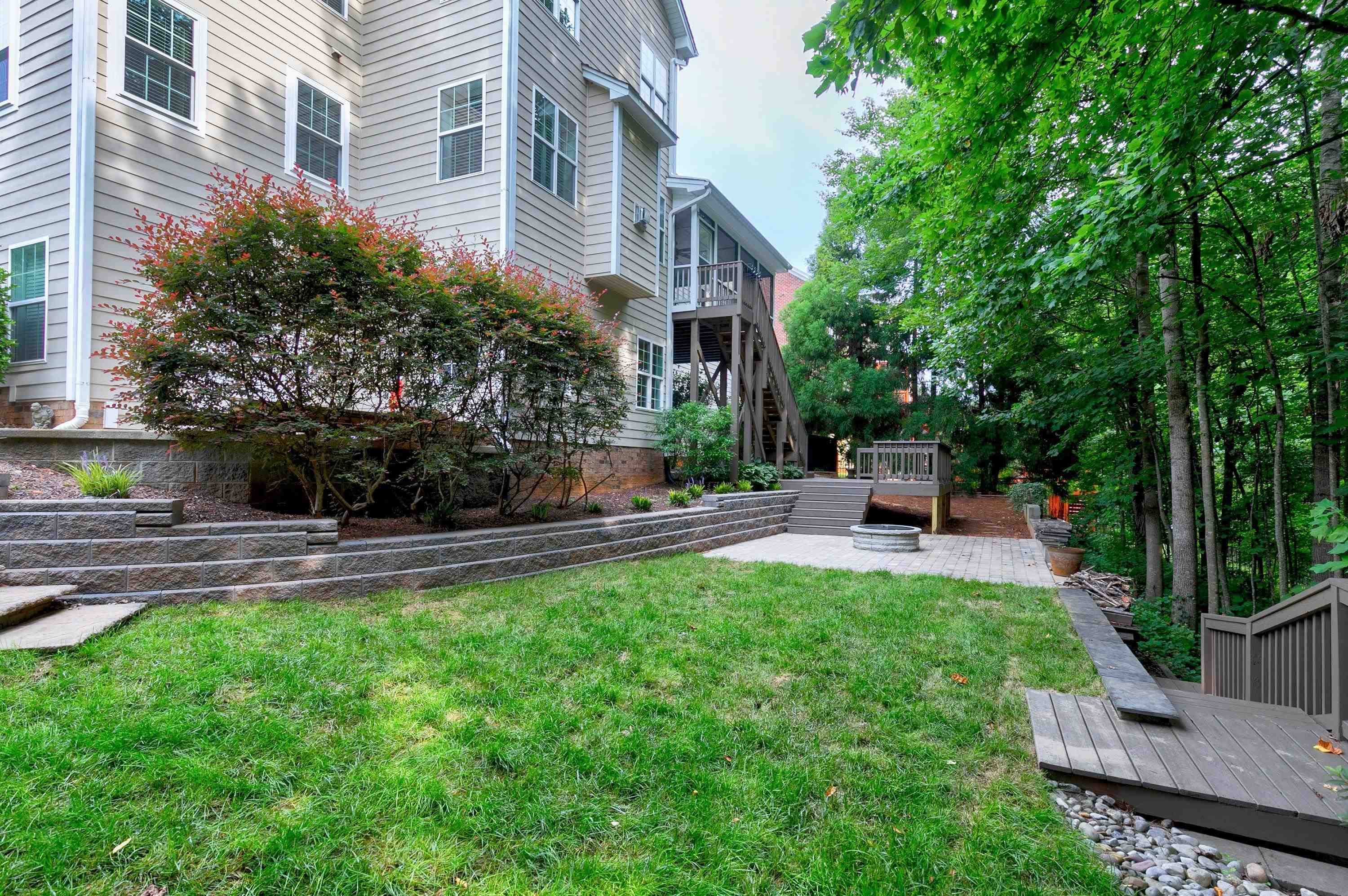 8431 Henderson Road Apex, NC 27539 - Photo 52 of 56 a view of a patio with couches and a table and chairs with plants and trees