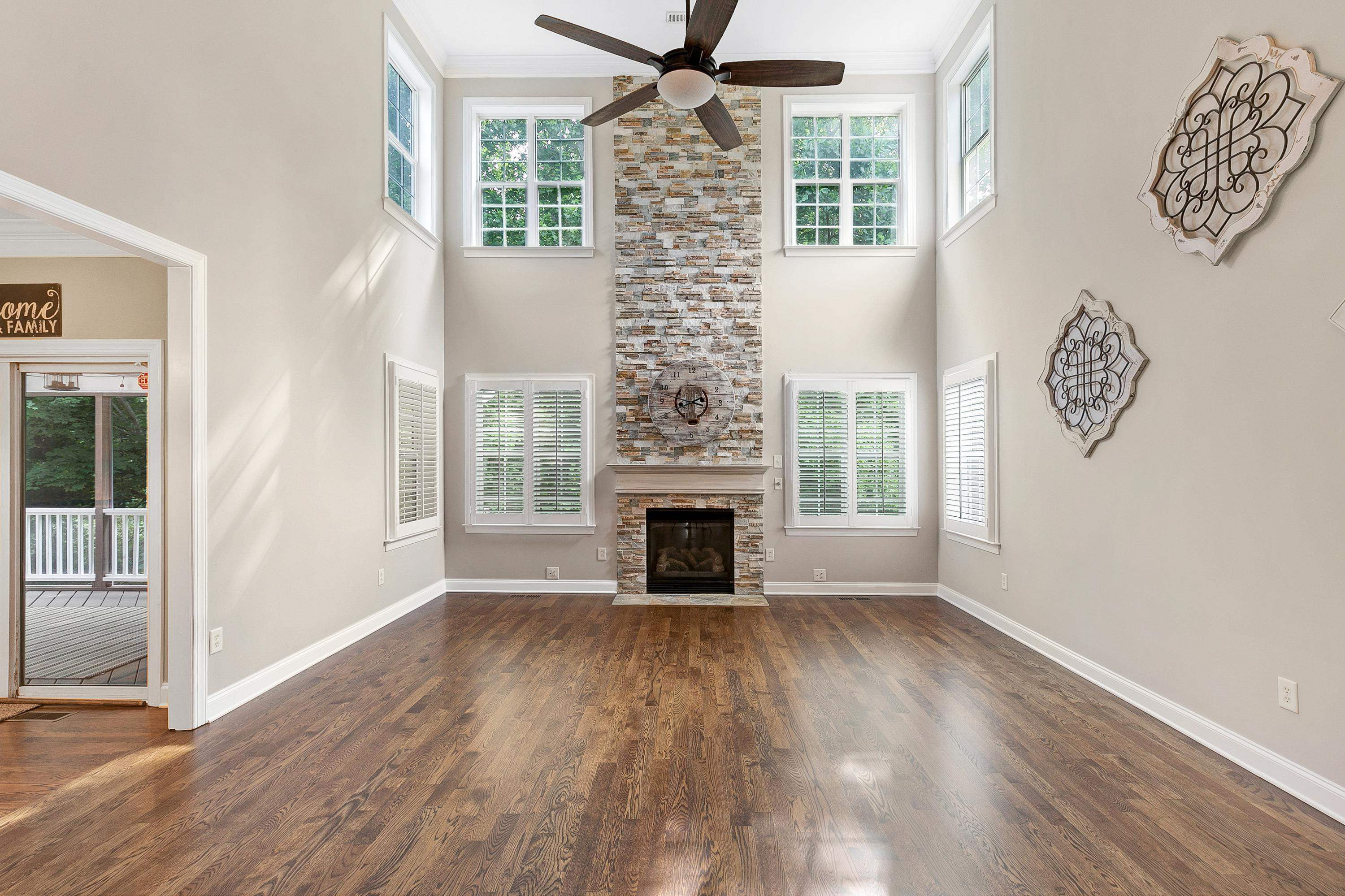 8431 Henderson Road Apex, NC 27539 - Photo 8 of 56 a view of a livingroom with wooden floor a fireplace and windows