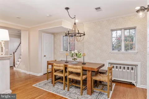 a view of a dining room and livingroom with furniture wooden floor a chandelier