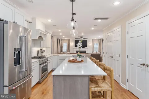 a kitchen with stainless steel appliances a stove a sink a dining table and chairs