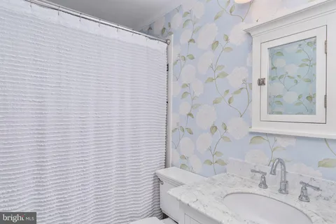 a bedroom with a large bed and a flat tv screen on dresser