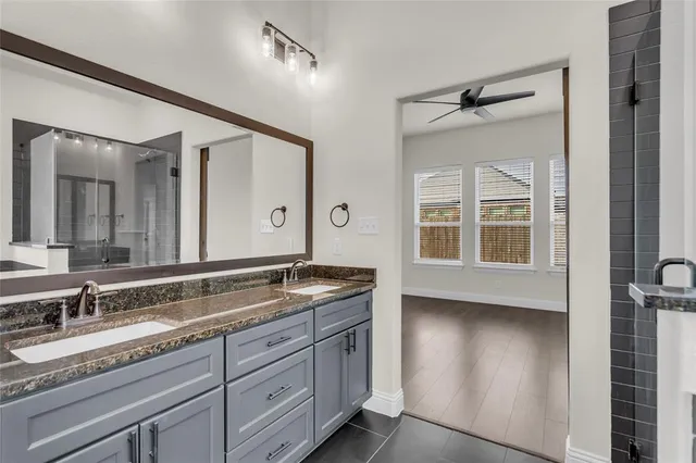 a bathroom with a granite countertop sink mirror and cabinets