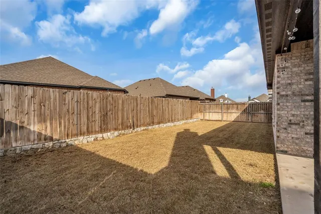 a view of backyard with wooden fence
