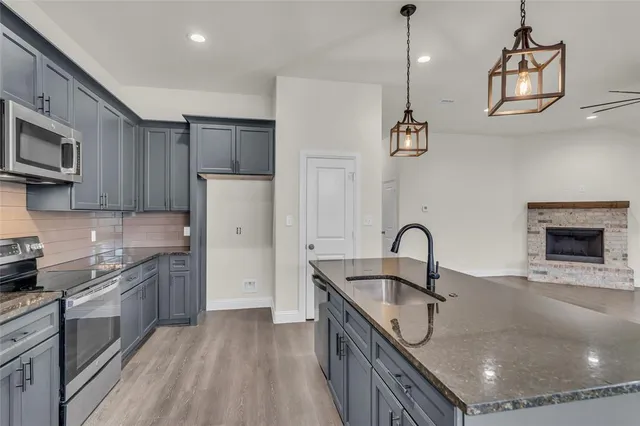 a kitchen with kitchen island a sink appliances and cabinets