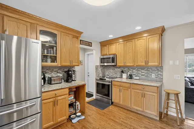 a view of a kitchen with refrigerator and wooden floor