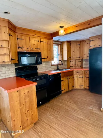 a kitchen with stainless steel appliances granite countertop a sink and wooden cabinets