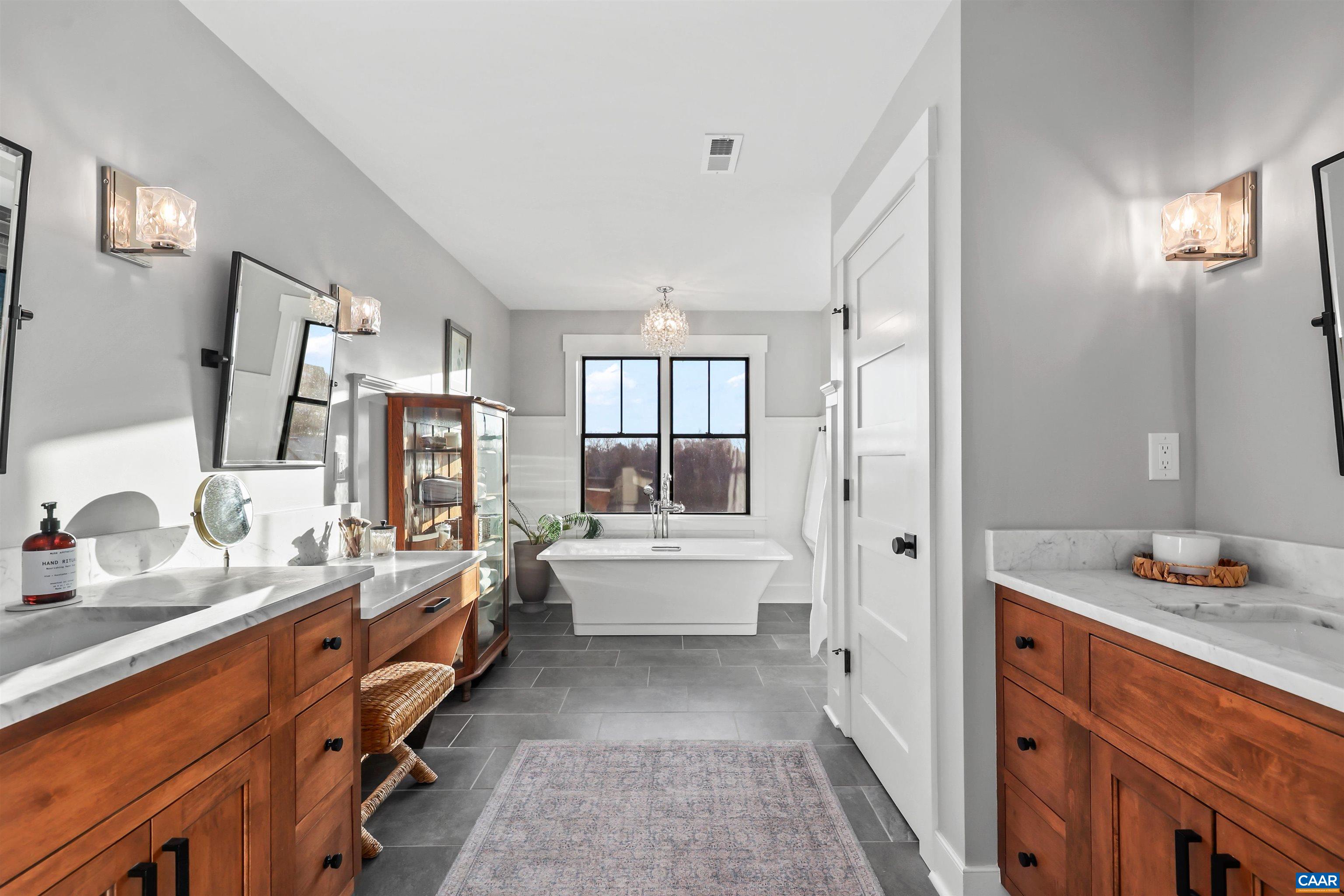 5797 Advance Mills Road Advance Mills, VA 22968 - Photo 42 of 70 a bathroom with double vanity sinks a mirror and a bathtub