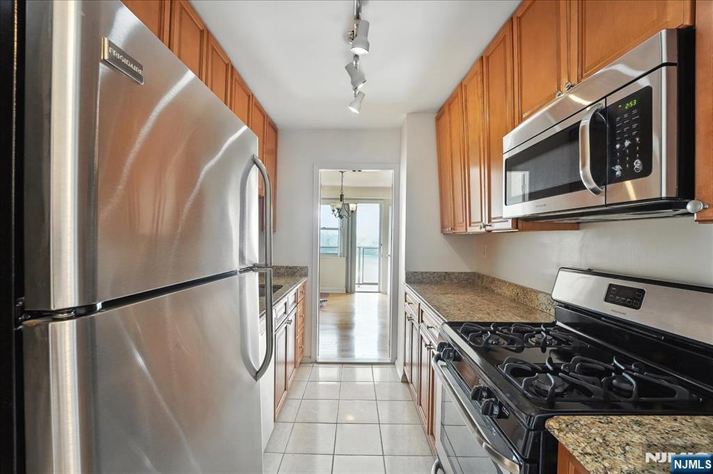 6600 JFK Boulevard East, Unit 18L West New York, NJ 07093 - Photo 11 of 36 a kitchen with stainless steel appliances granite countertop a refrigerator a stove and a microwave