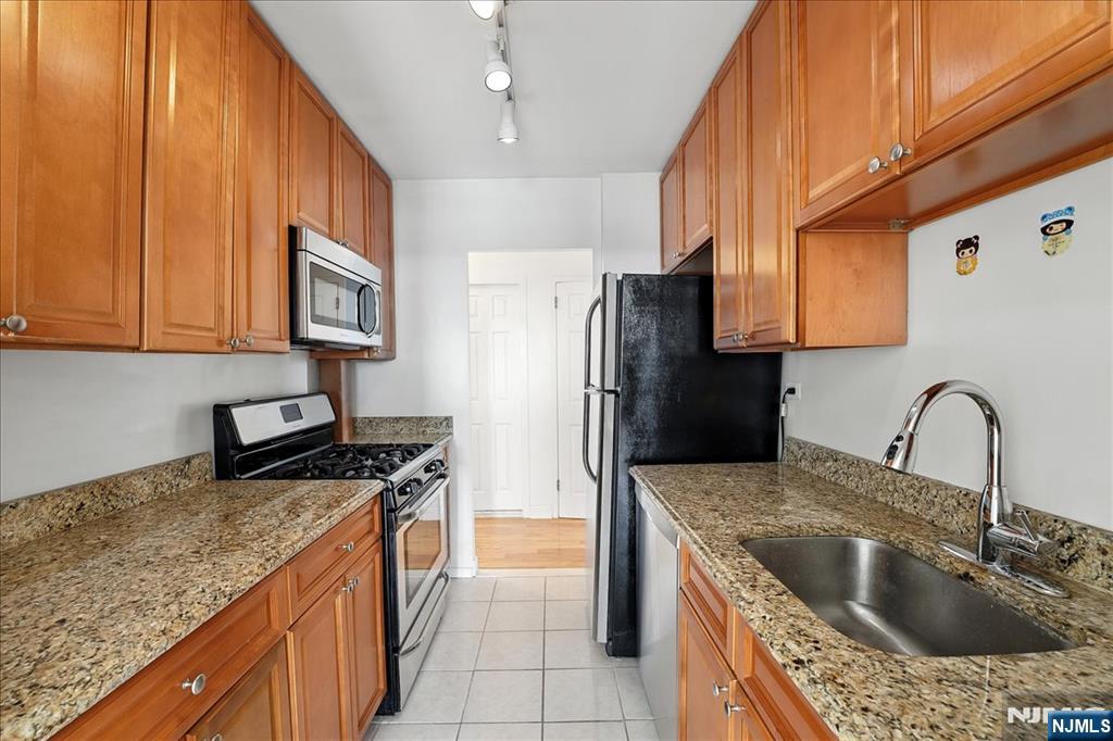 6600 JFK Boulevard East, Unit 18L West New York, NJ 07093 - Photo 12 of 36 a kitchen with stainless steel appliances granite countertop a sink a stove and a refrigerator