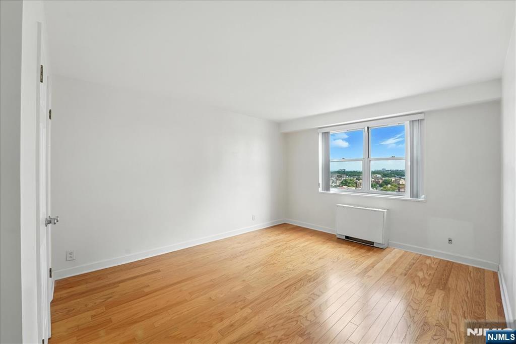 6600 JFK Boulevard East, Unit 18L West New York, NJ 07093 - Photo 20 of 36 wooden floor in an empty room with a window
