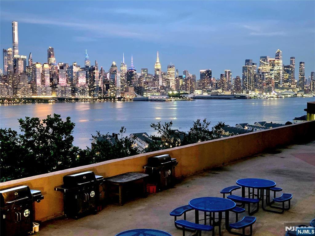 6600 JFK Boulevard East, Unit 18L West New York, NJ 07093 - Photo 7 of 36 a view of a city chairs and a table in the river