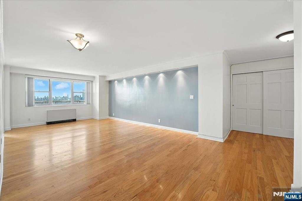 6600 JFK Boulevard East, Unit 18L West New York, NJ 07093 - Photo 10 of 36 a view of an empty room with a window and wooden floor