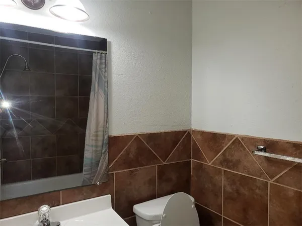 a bathroom with a shower toilet and a sink