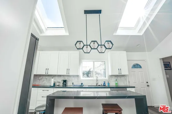 a kitchen with stainless steel appliances a sink a stove and a window