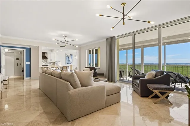 a living room with furniture ceiling fan and a large window