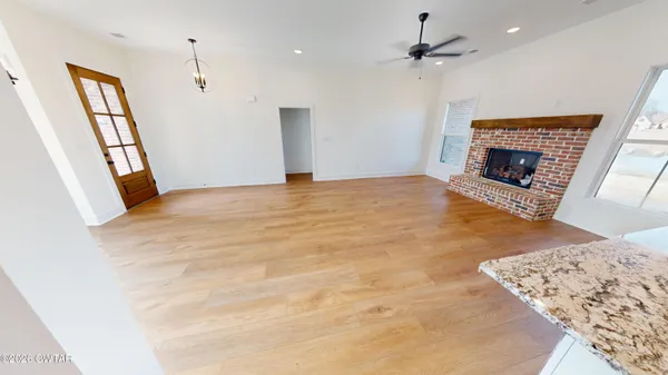 a view of a hallway with wooden floor and entryway