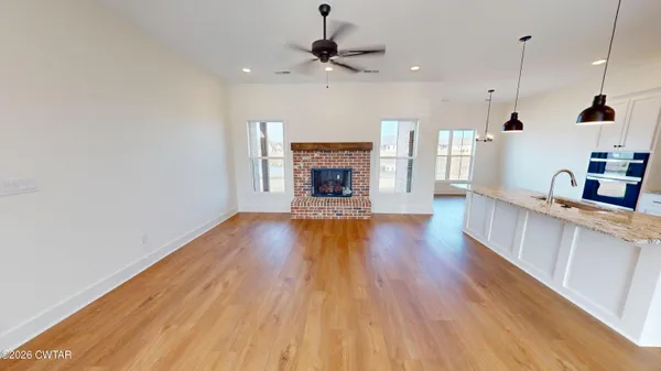 a large kitchen with stainless steel appliances kitchen island a large counter top and a wooden floors