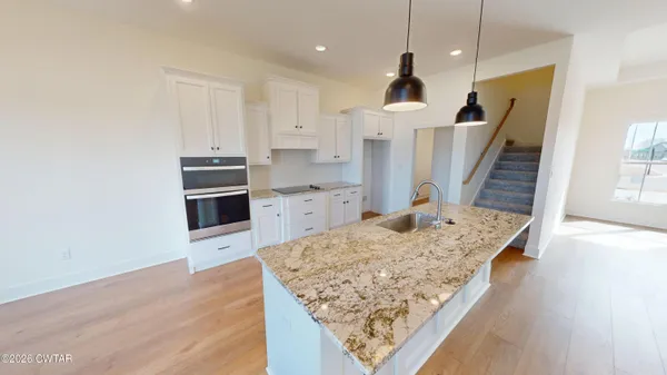 a kitchen with granite countertop white cabinets and white appliances