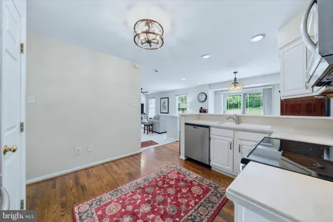 a kitchen with a sink dishwasher a stove and a oven with wooden floor