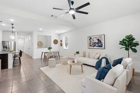 a living room with furniture and a dining table with wooden floor