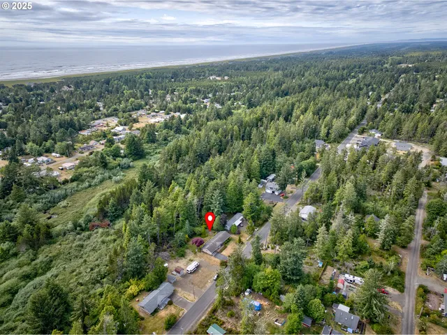 an aerial view of residential houses with outdoor space and trees