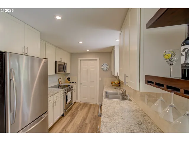 a kitchen with stainless steel appliances a refrigerator and a stove top oven