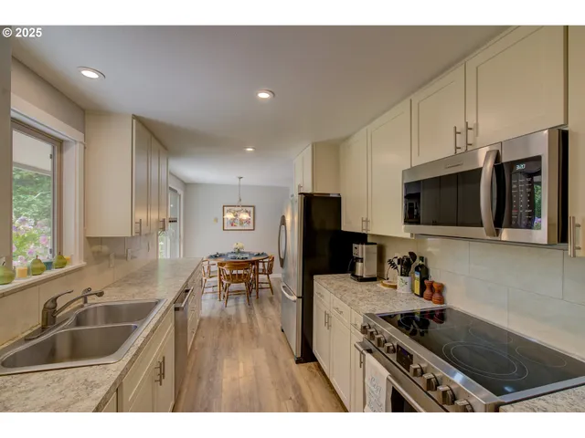 a kitchen with granite countertop a sink and a stove top oven with wooden floor