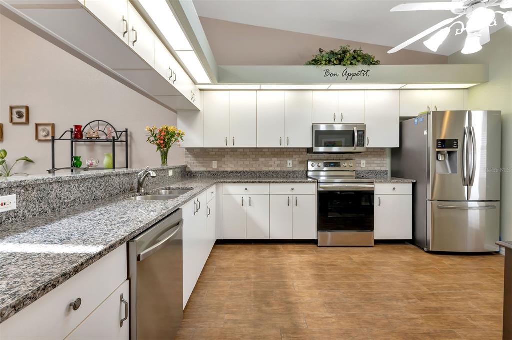 5036 San Rocco Court Punta Gorda, FL 33950 - Photo 7 of 13 a kitchen with stainless steel appliances granite countertop a sink stove and refrigerator