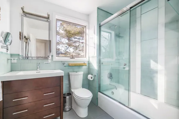 a bathroom with a sink a toilet and shower