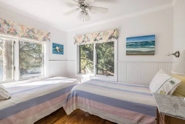 a view of a bedroom with baby crib and lounge chair