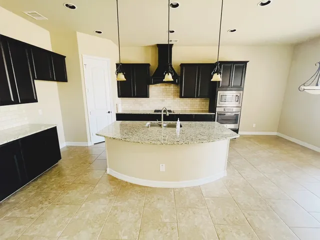 a kitchen with stainless steel appliances granite countertop a sink a refrigerator and a stove