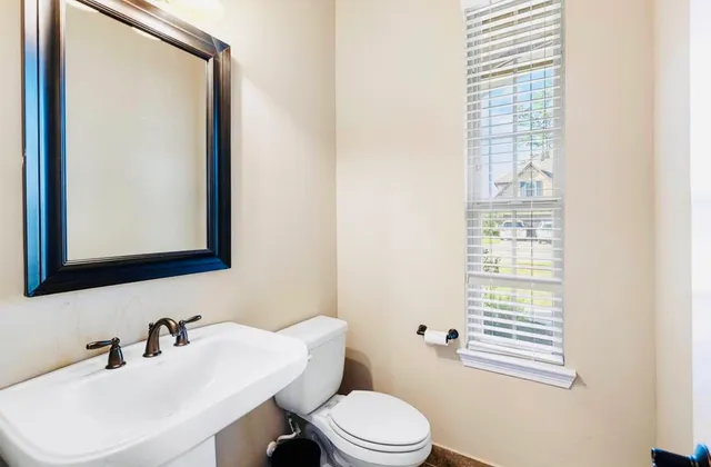 a bathroom with a toilet a sink and mirror