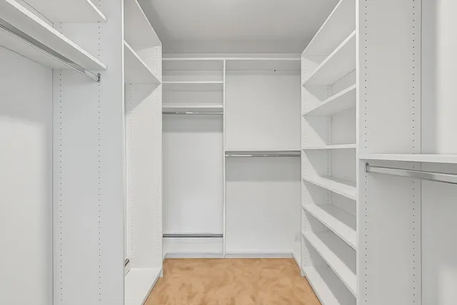 a view of walk in closet with empty racks
