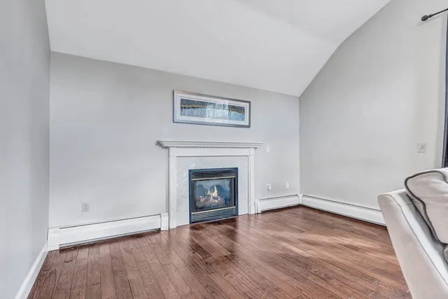 an empty room with wooden floor and fireplace