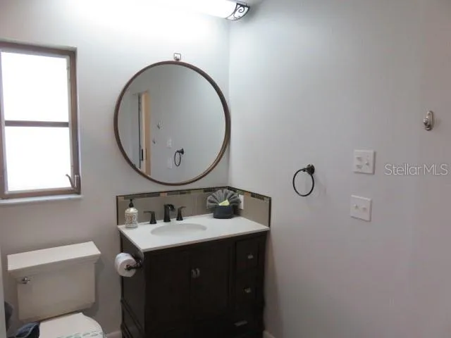 a bathroom with a sink mirror and toilet