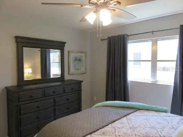 a bedroom with a bed and a mirror on dresser