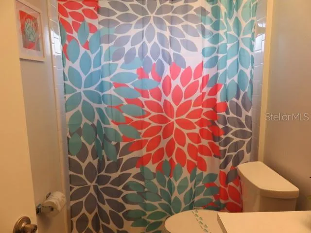 a bathroom with a toilet and a shower curtain