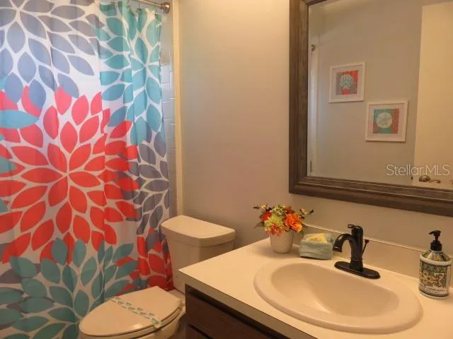 a bathroom with a sink toilet and mirror