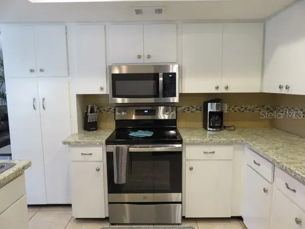 a kitchen with cabinets stainless steel appliances and wooden cabinets