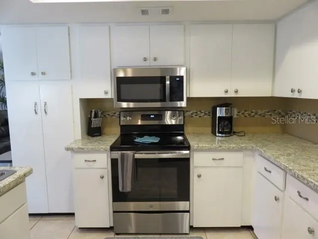 a kitchen with cabinets stainless steel appliances and wooden cabinets