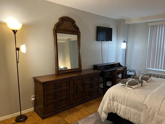 a bedroom with a bed and a mirror on dresser