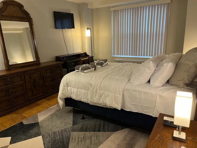 a bedroom with a bed a mirror and dresser