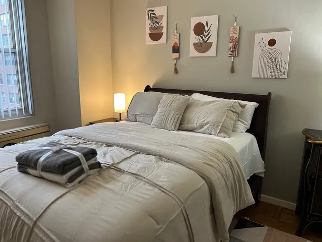 a bedroom with a bed and painting on the wall