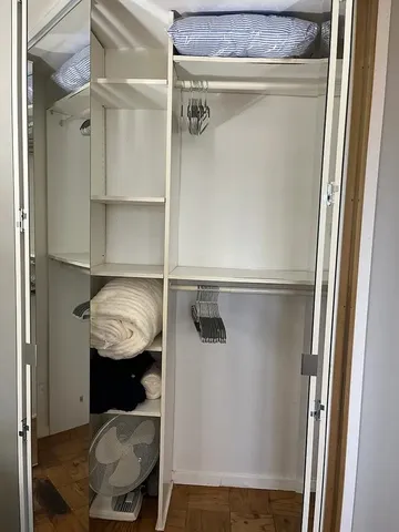 a view of walk in closet with clothes and shoes