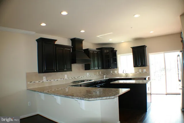 a kitchen with stainless steel appliances granite countertop a sink and a refrigerator