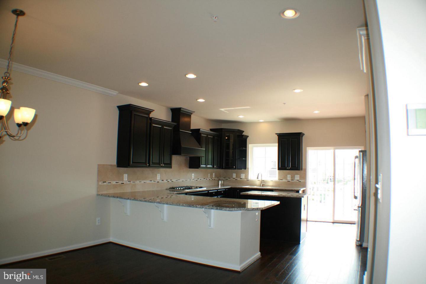 7581 Crowley Street Hanover, MD 21076 - Photo 5 of 19 a large white kitchen with a sink and dishwasher a stove with wooden floor