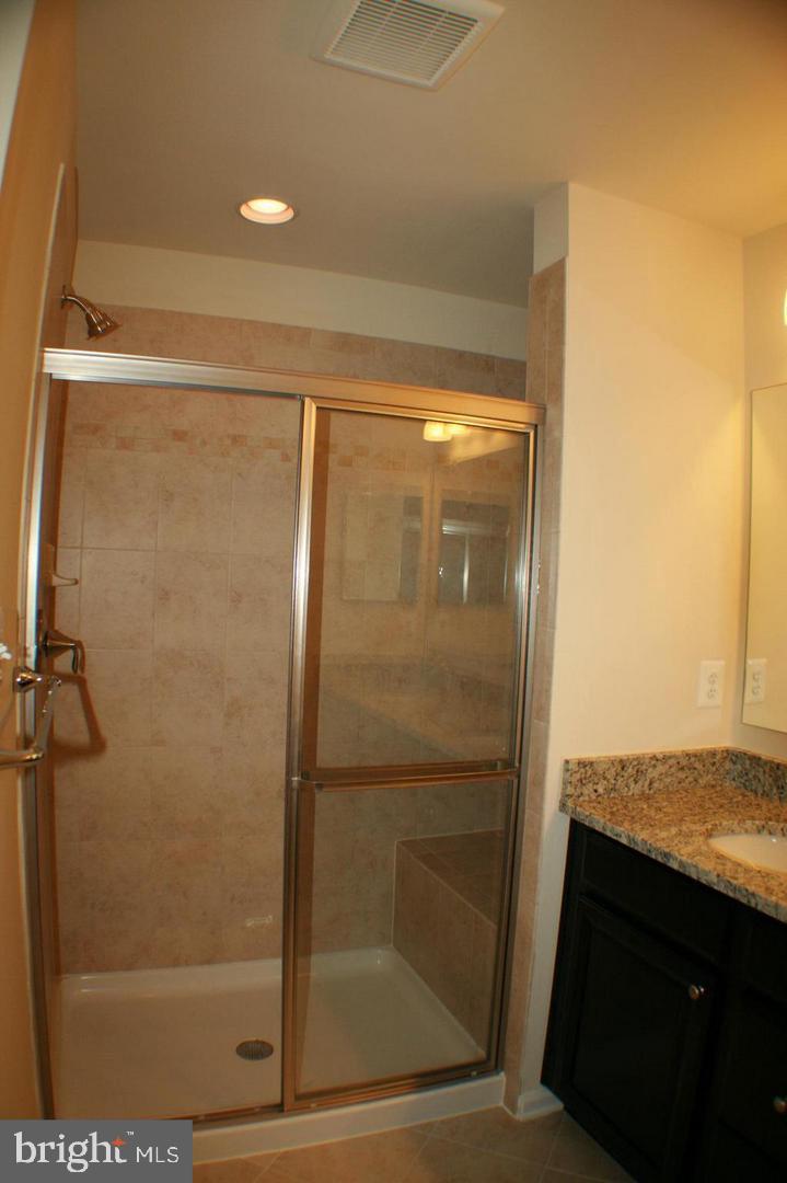 7581 Crowley Street Hanover, MD 21076 - Photo 9 of 19 a bathroom with a glass shower door