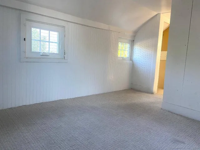 an empty room with windows and closet