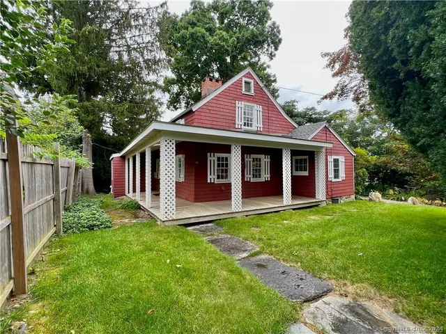 a view of a yard in front of a house with large tree